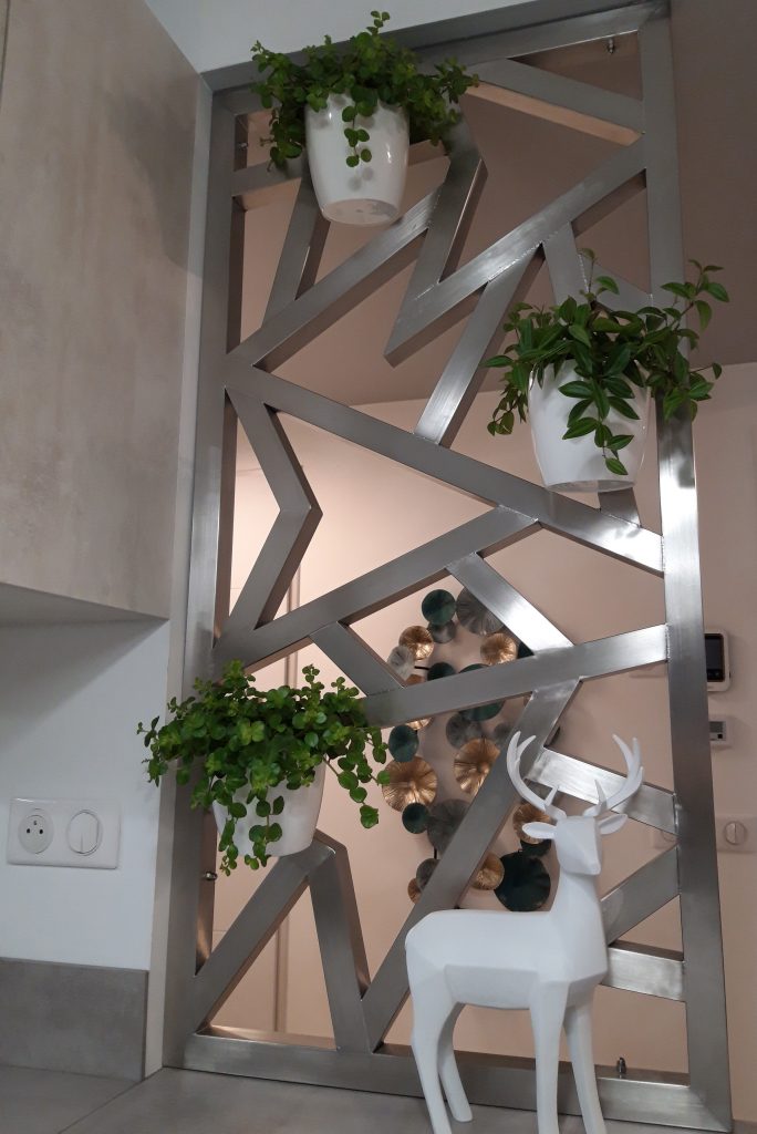 Claustra moderne, en acier inoxydable pour séparer un couloir d'entrée et une cuisine.