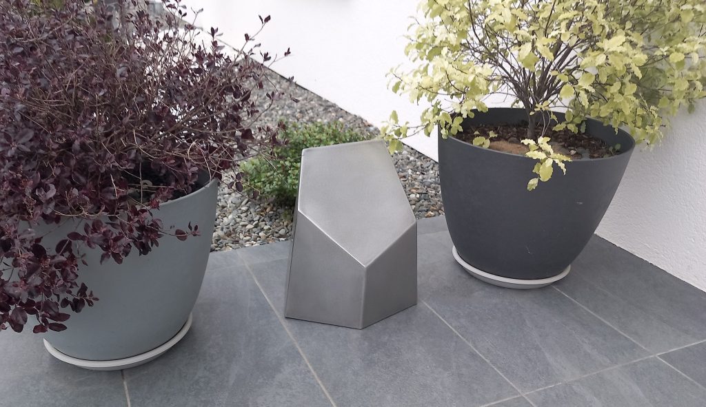 Prisme en acier inoxydable pour décorer un jardin. Hauteur 30 centimètres et largeur environ 25 centimètres.