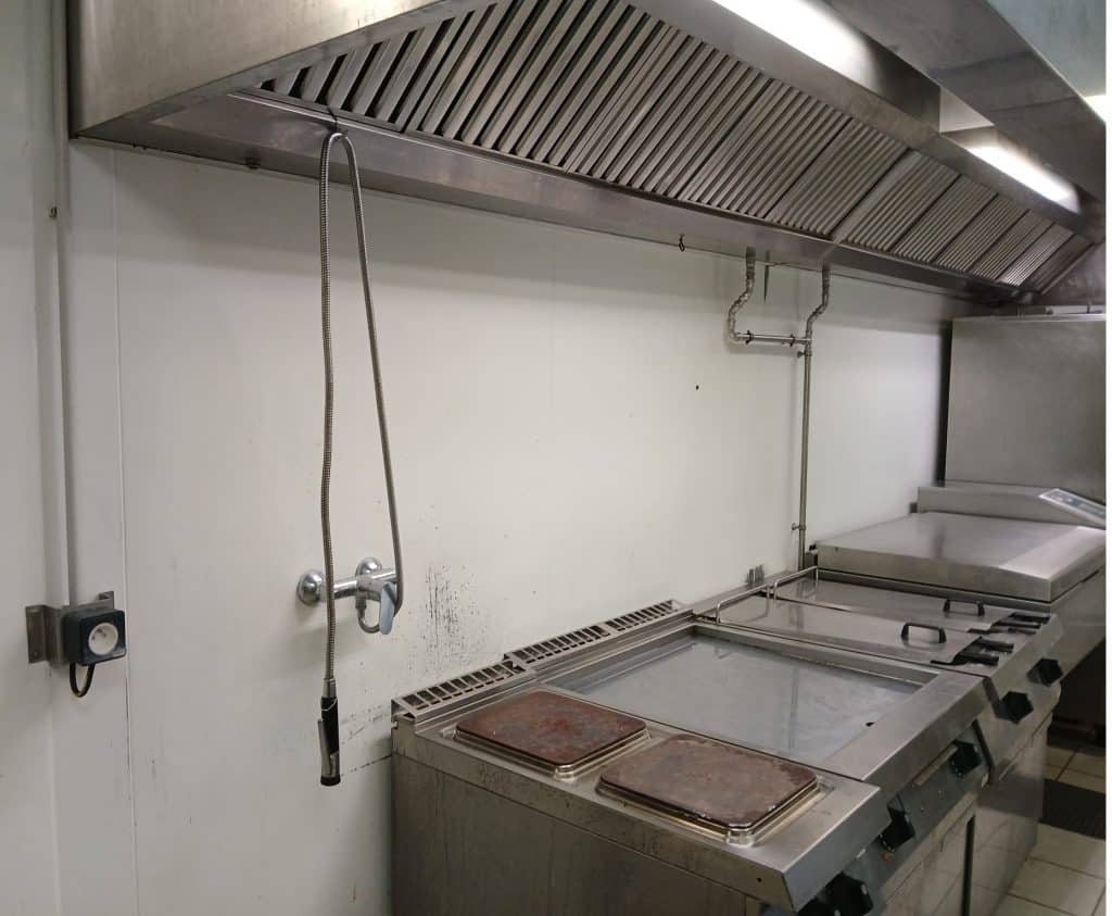 Remise aux normes de conformité d'une cuisine d'un établissement de santé, avec la conception et l'installation d'une crédence sur mesure, en acier inoxydable. Photo avant installation.