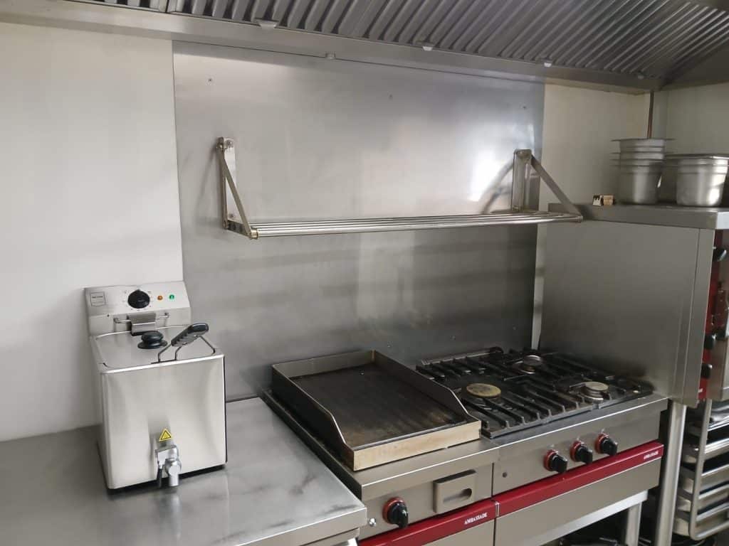 Remise aux normes de conformité d'une cuisine de restaurateur, avec la conception et l'installation d'une crédence sur mesure, en acier inoxydable. Photo après installation.