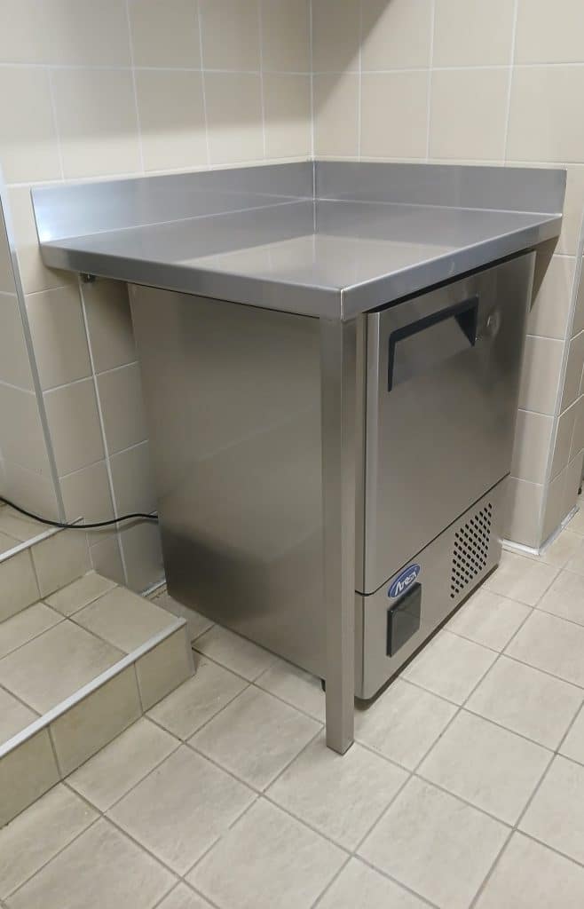 Fabrication d'un plan de travail sur mesure en acier inoxydable pour la cuisine d'un cinéma.